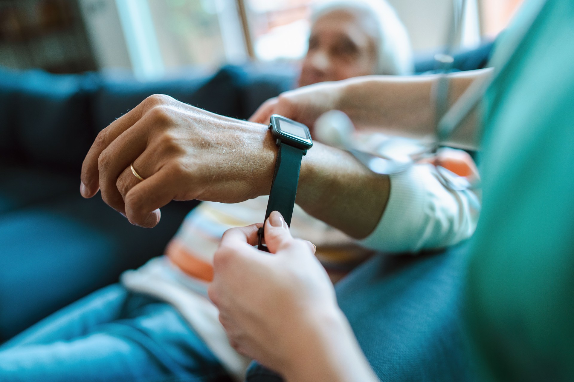 Smartwatch for assisted living. A woman from the medical health system wears a smartwatch for remote monitoring of vital signs on an elderly person